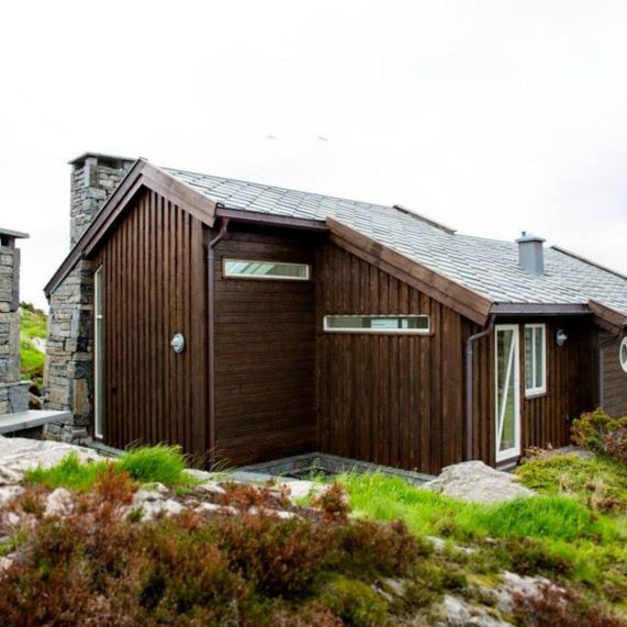 Hus med mange store vindu og stein detaljer på grunnmur